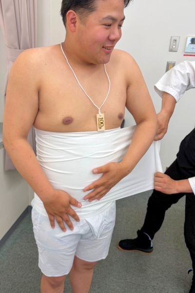 さらしを巻いてもらう様子①